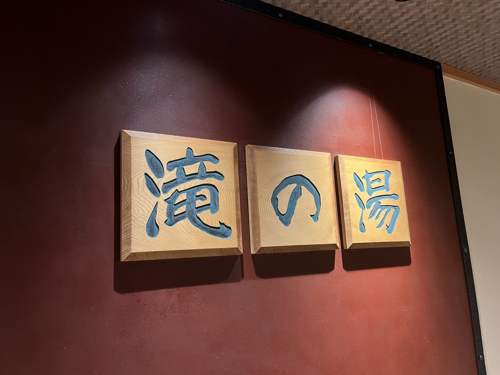 鬼怒川溫泉站前廣場,前景是手持棒槌的鬼怒太青銅雕像,背景為群山與溫泉旅館街