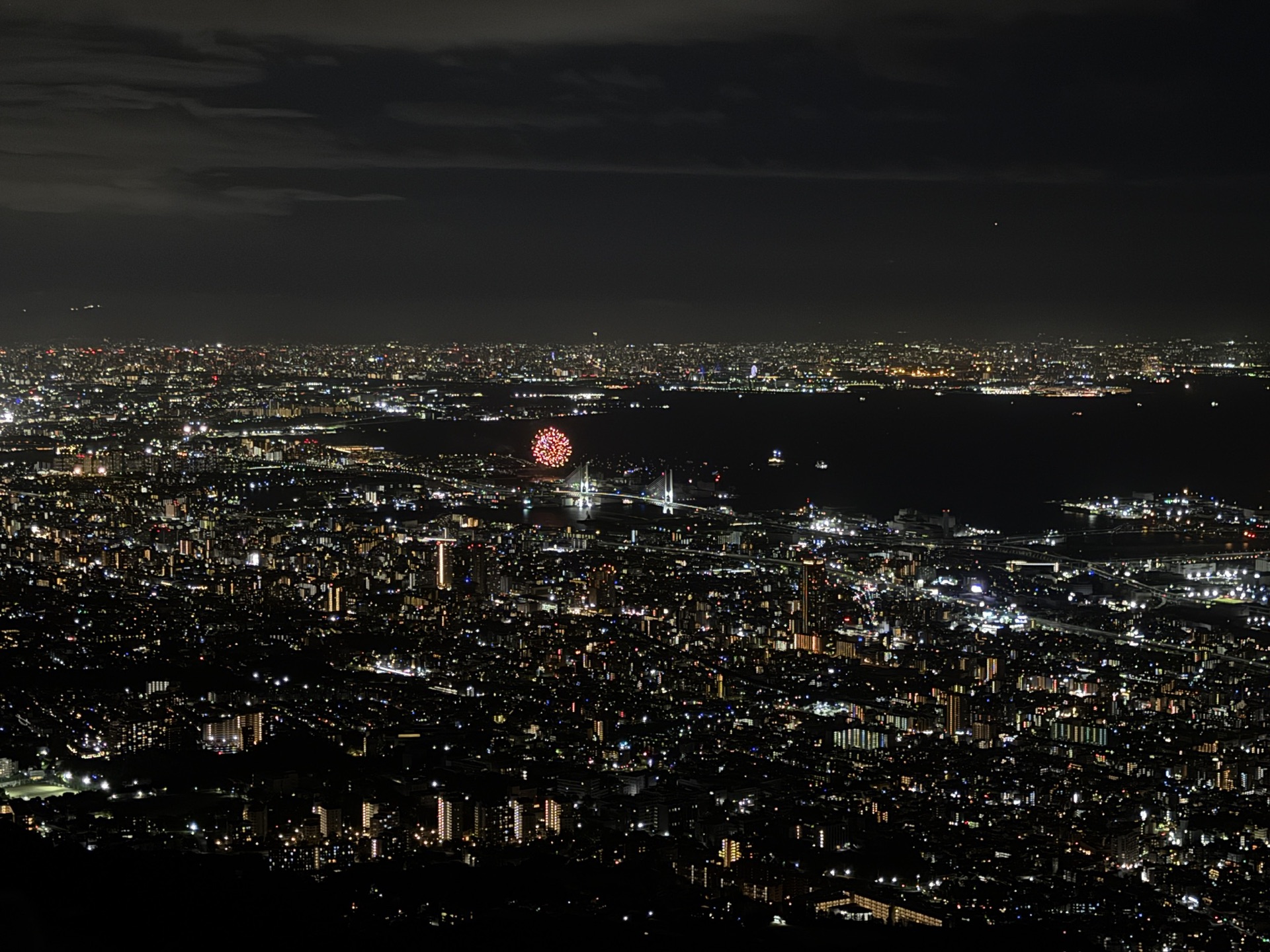 從摩耶山掬星台俯瞰的大阪灣夜景全景,烏雲後方透出城市燈光,視野遼闊