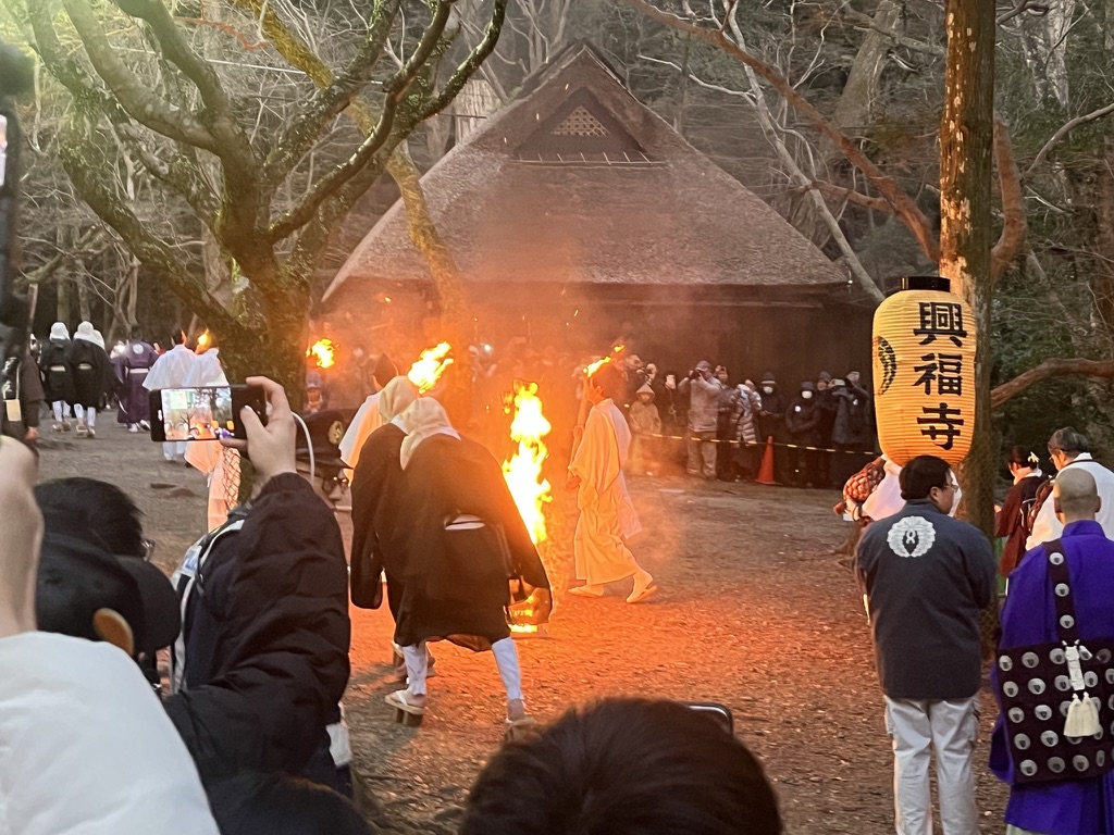 若草山燒山祭，整片山坡火線延伸，山腳觀眾手機燈點點