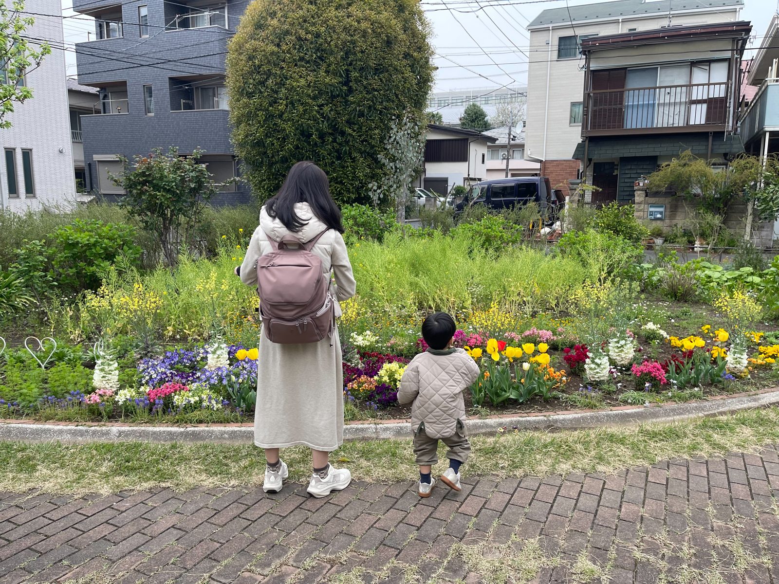 His family and child in front of a flower bed.